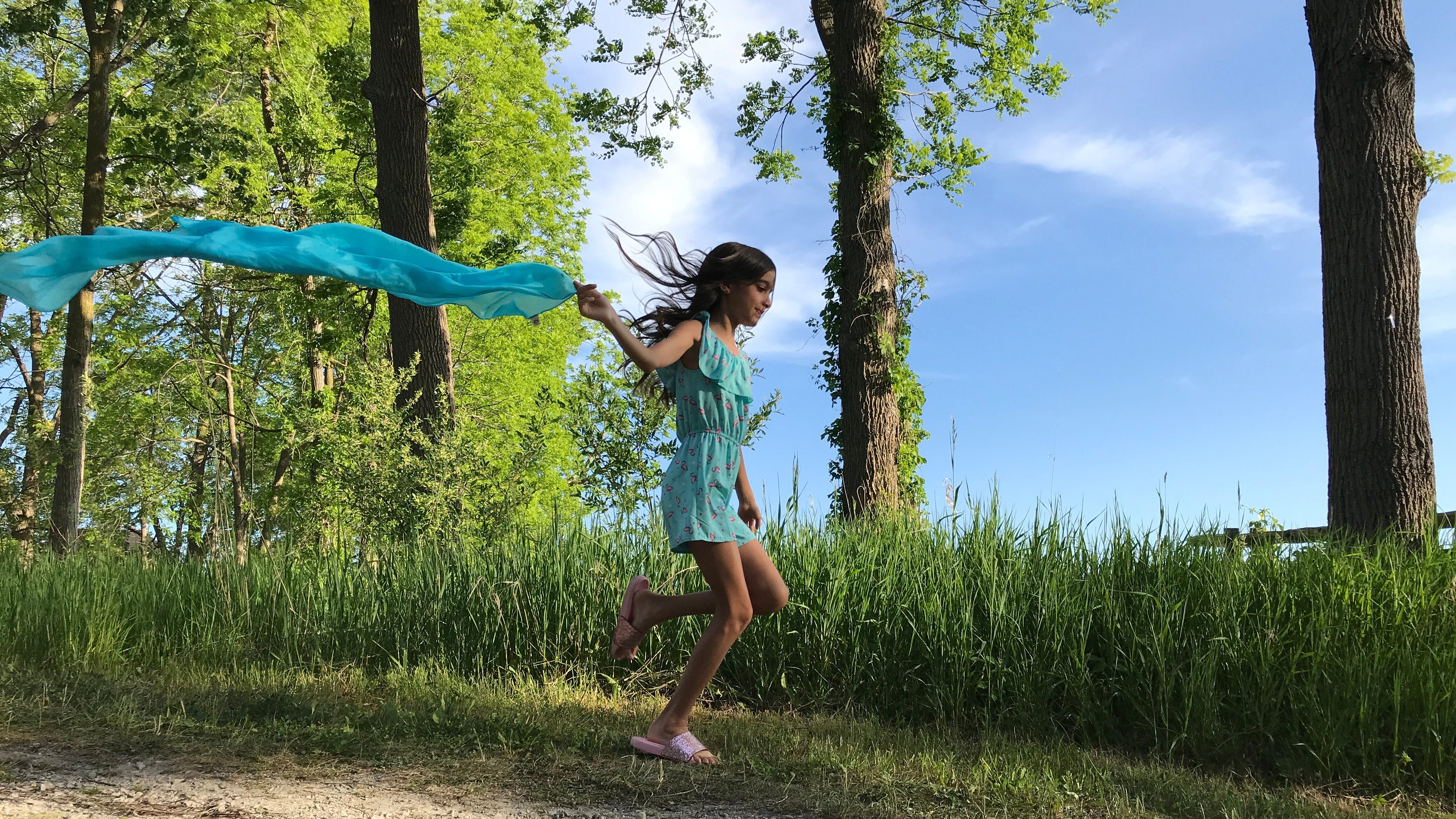 Photo of girl running with blue playsilk